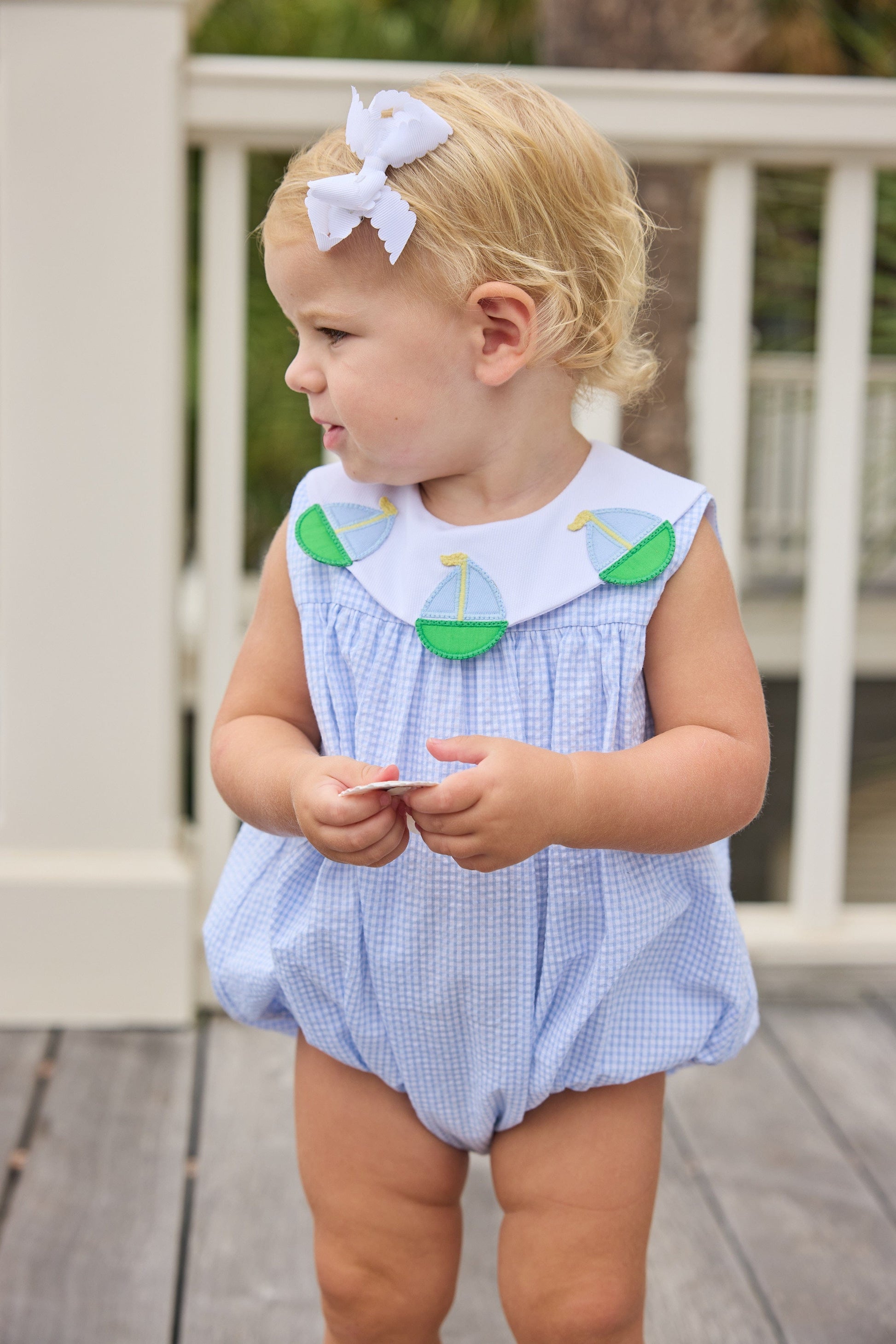 Little English traditional children's clothing.  Light blue seersucker gingham bubble with white bib collar and applique sailboats for baby girls.