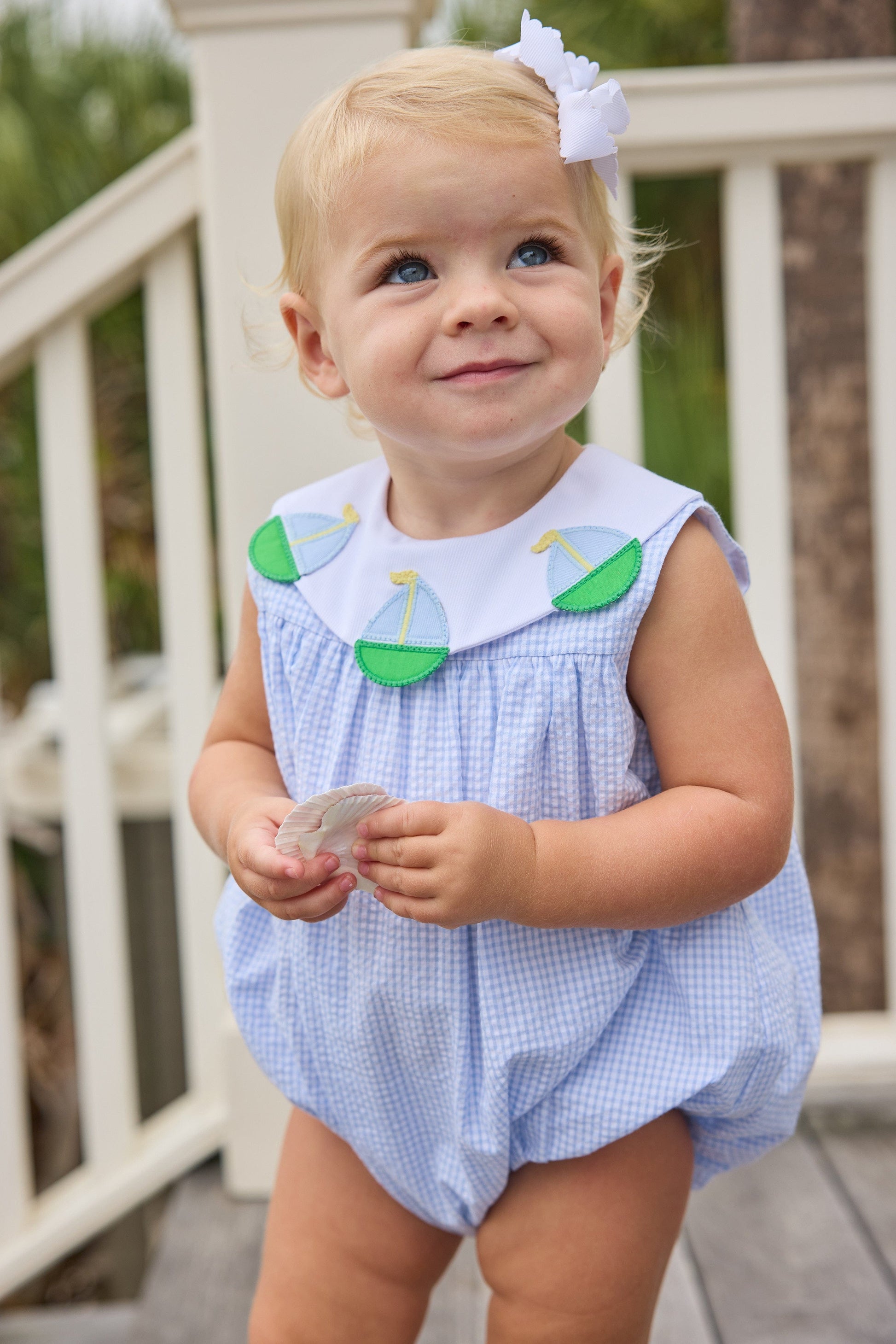 Little English traditional children's clothing.  Light blue seersucker gingham bubble with white bib collar and applique sailboats for baby girls.