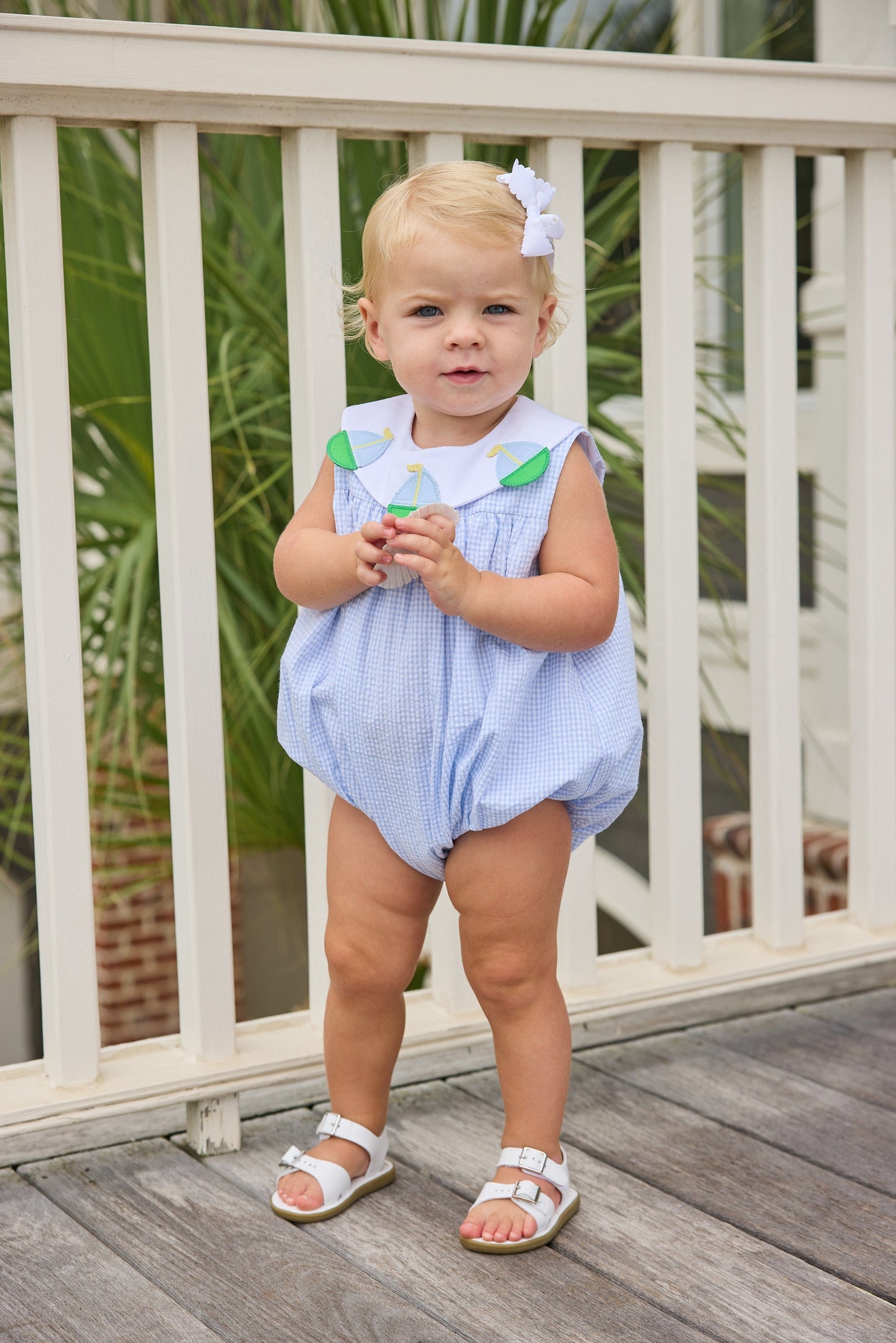 Little English traditional children's clothing.  Light blue seersucker gingham bubble with white bib collar and applique sailboats for baby girls.