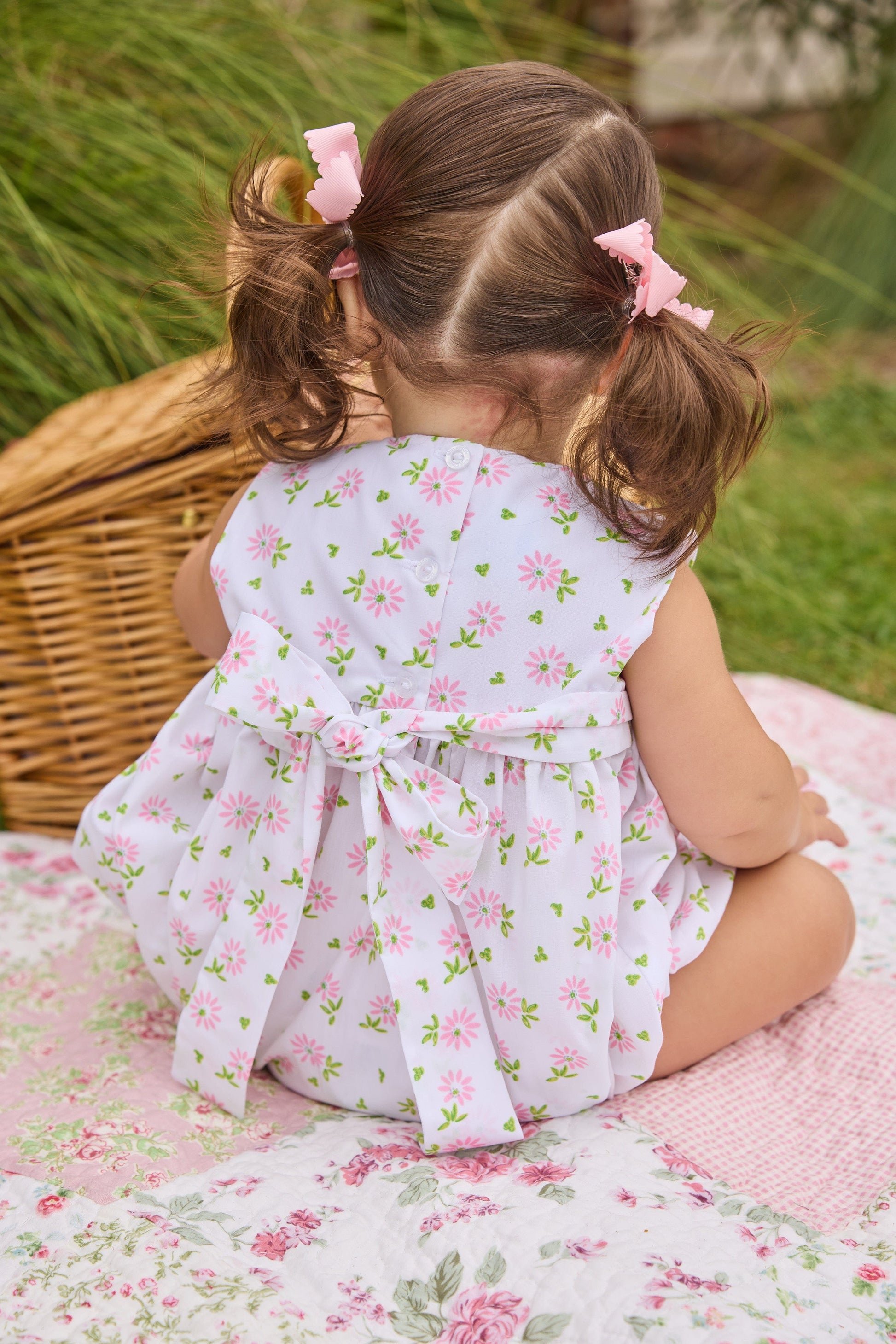 Little English traditional children's clothing.  White sleeveless smocked bubble with pink and green florals for baby girls