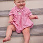 Little English traditional children's clothing.  Classic peter pan bubble for baby boys in red seersucker gingham fabric and lab smocking at the chest
