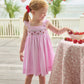 Little English traditional children's clothing.  Light pink seersucker gingham dress for little girls with flutter sleeves and strawberry smocking across the chest