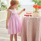 Little English traditional children's clothing.  Light pink seersucker gingham dress for little girls with flutter sleeves and strawberry smocking across the chest