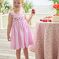 Little English traditional children's clothing.  Light pink seersucker gingham dress for little girls with flutter sleeves and strawberry smocking across the chest