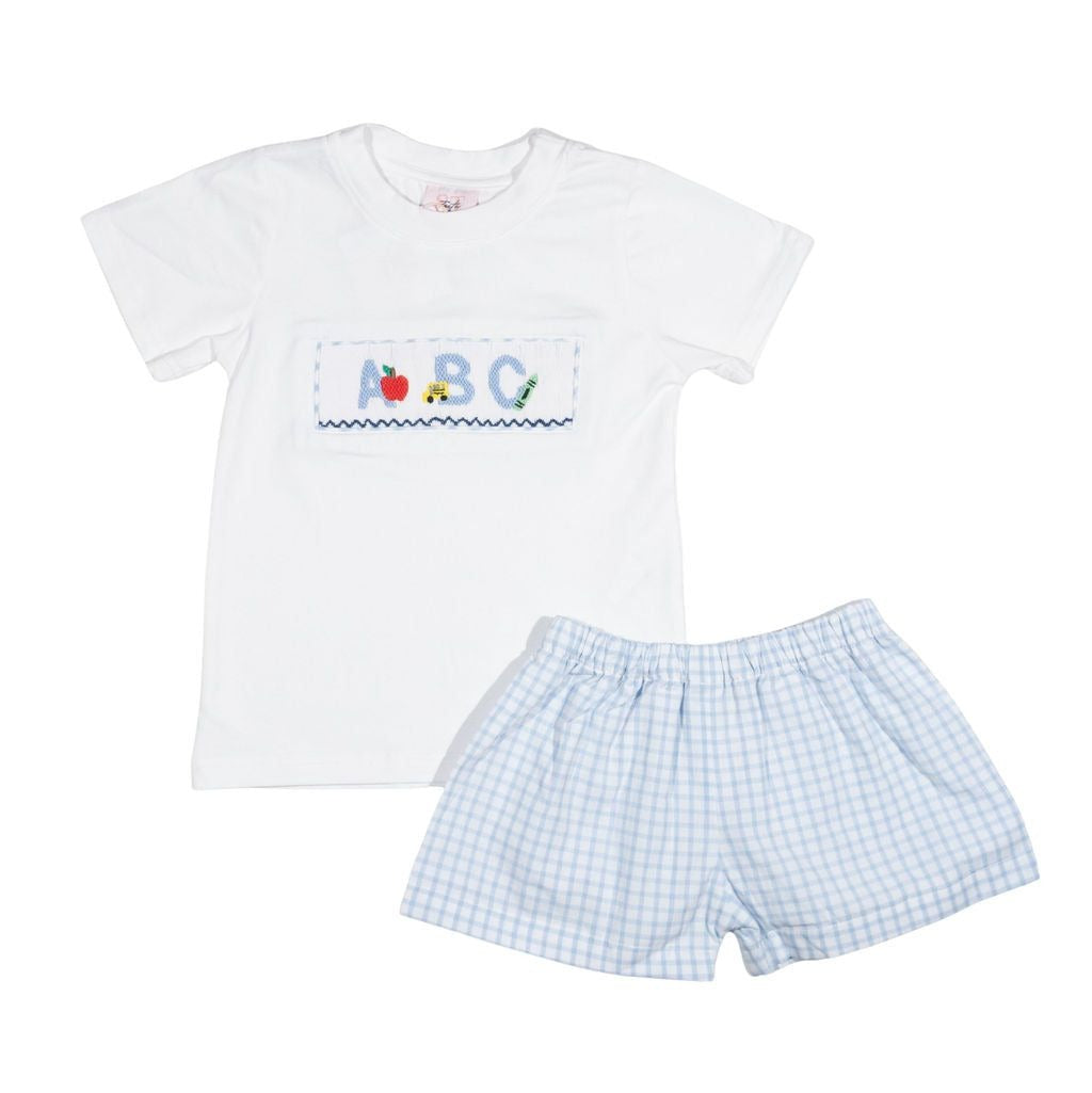 Children's white t-shirt with ABC design and checkered shorts on a white background