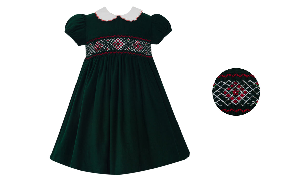 Green dress with red and white smocked detail on a white background