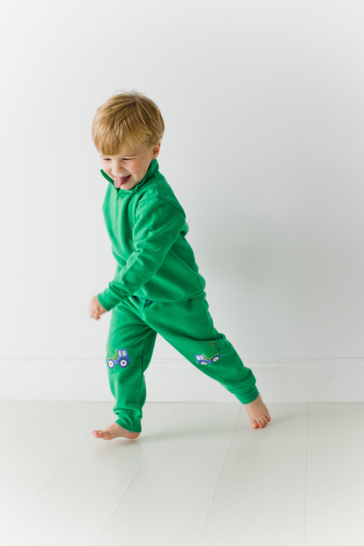 Toddler running in the green Tow Truck Scout Quarter Zip and matching Adventure Joggers