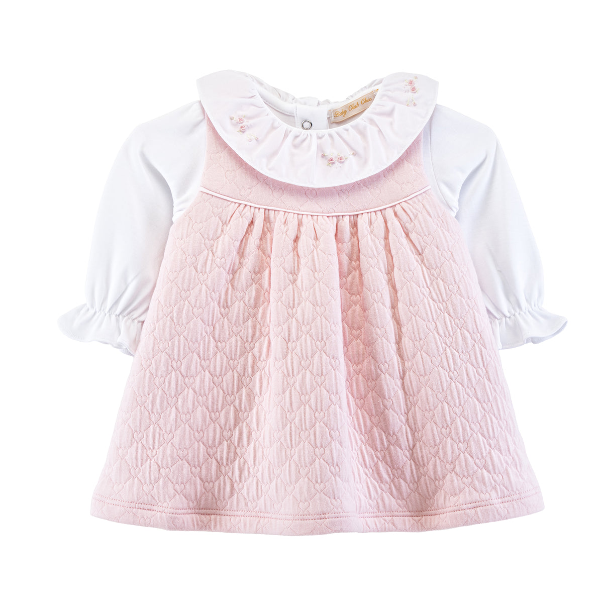 Baby dress with pink quilted top and white shirt on a white background