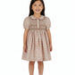 Young girl wearing a patterned dress on a white background