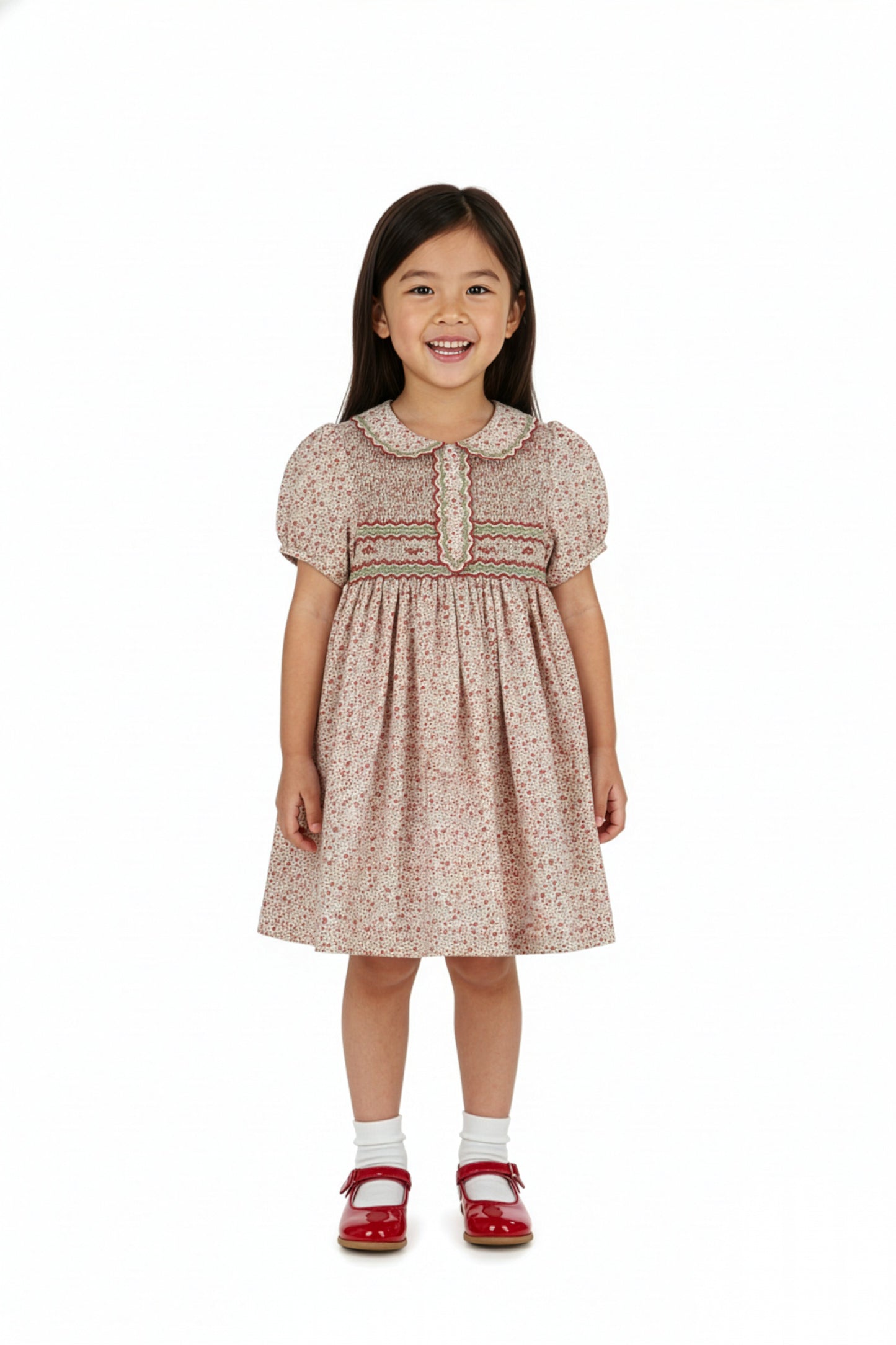 Young girl wearing a patterned dress on a white background