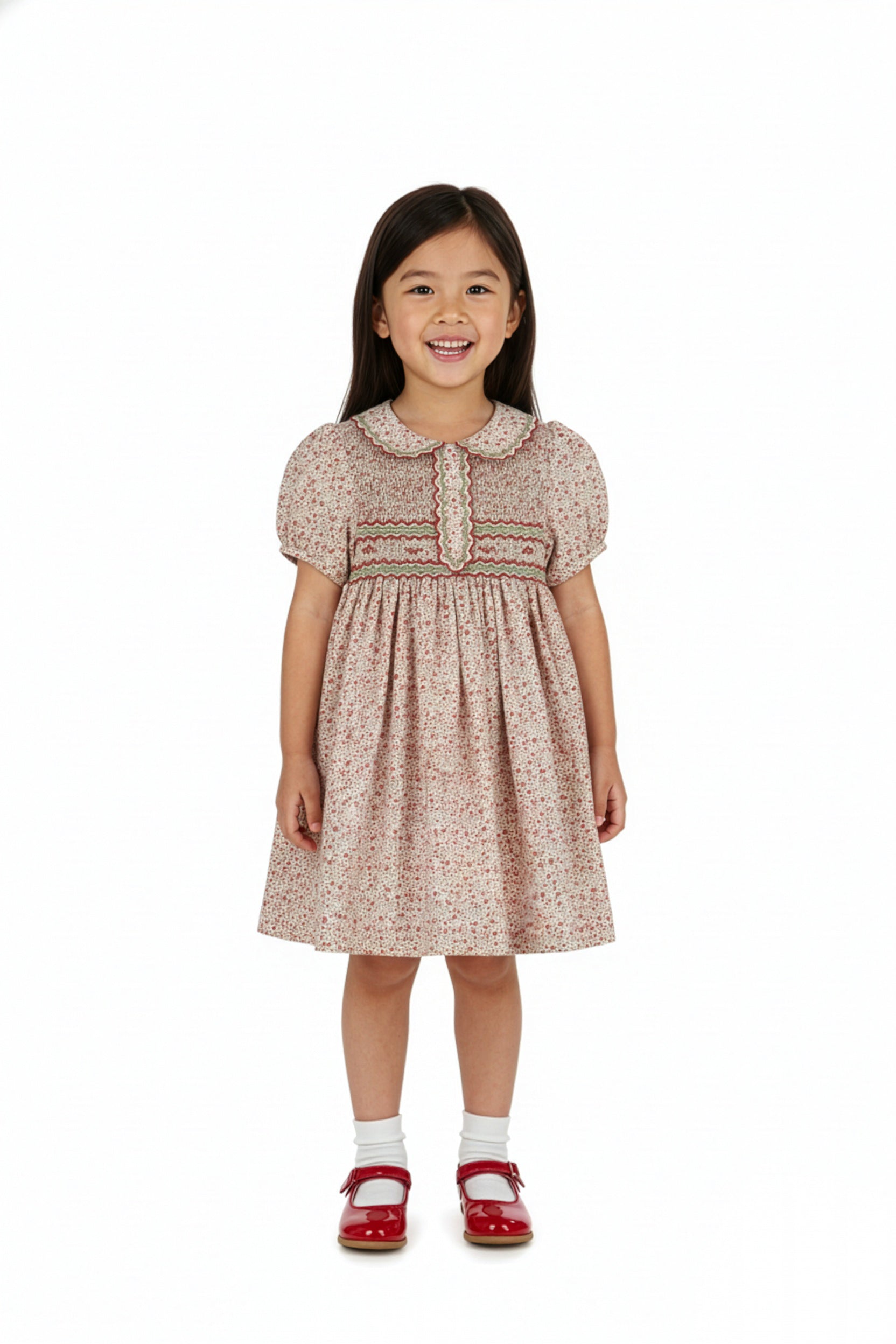 Young girl wearing a patterned dress on a white background