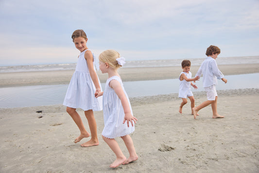 Little English traditional children's clothing.  Light blue and white striped sleeveless dress with white ricrac trim for little girls
