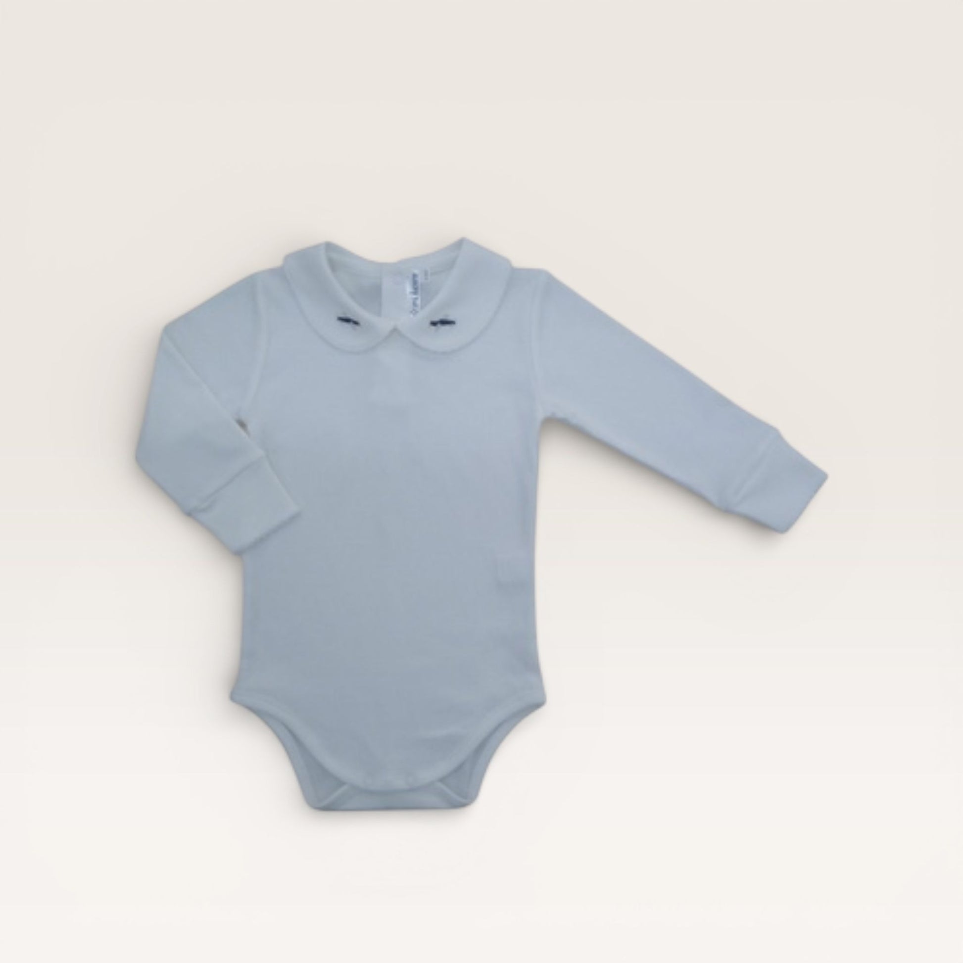 Light blue baby bodysuit with long sleeves on a beige background