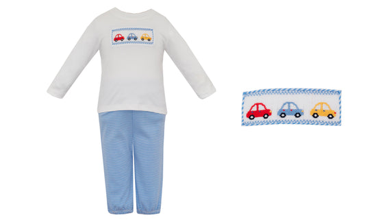 Children's pajama set with car design on shirt and pillowcase against a white background
