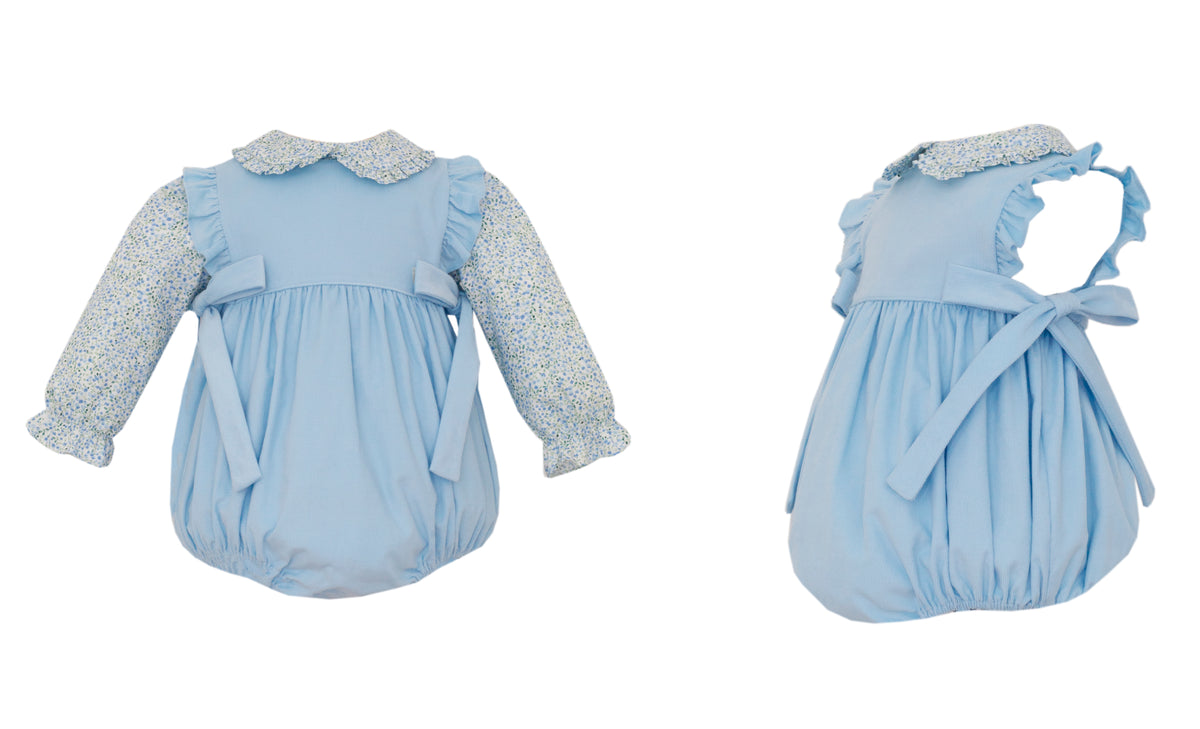 Two blue baby rompers with ruffled details on a white background