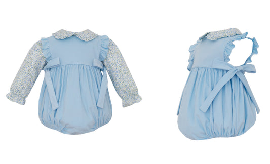 Two blue baby rompers with ruffled details on a white background