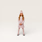 Young girl wearing a pink knitted dress and hat on a white background