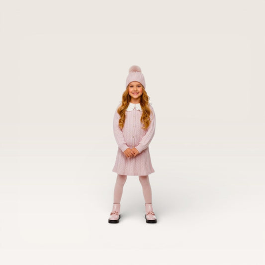 Young girl wearing a pink knitted dress and hat on a white background