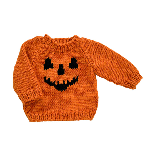 An orange sweater with a jack-o-lantern face design on the front.