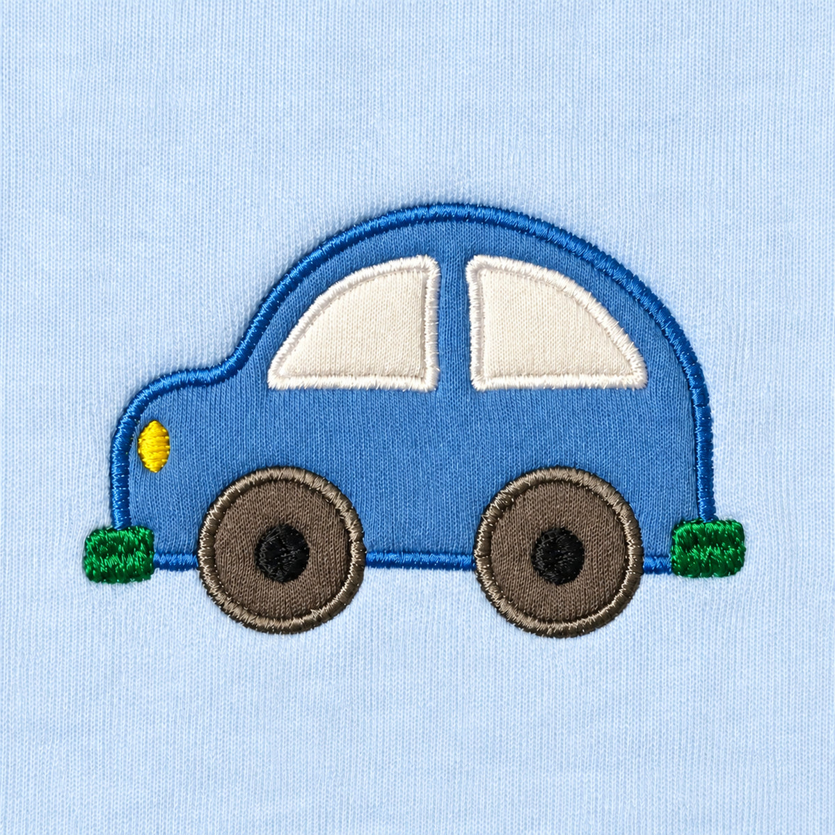 Close-up of the blue car appliqué with cream windows, grey wheels, green bumpers and a yellow headlight