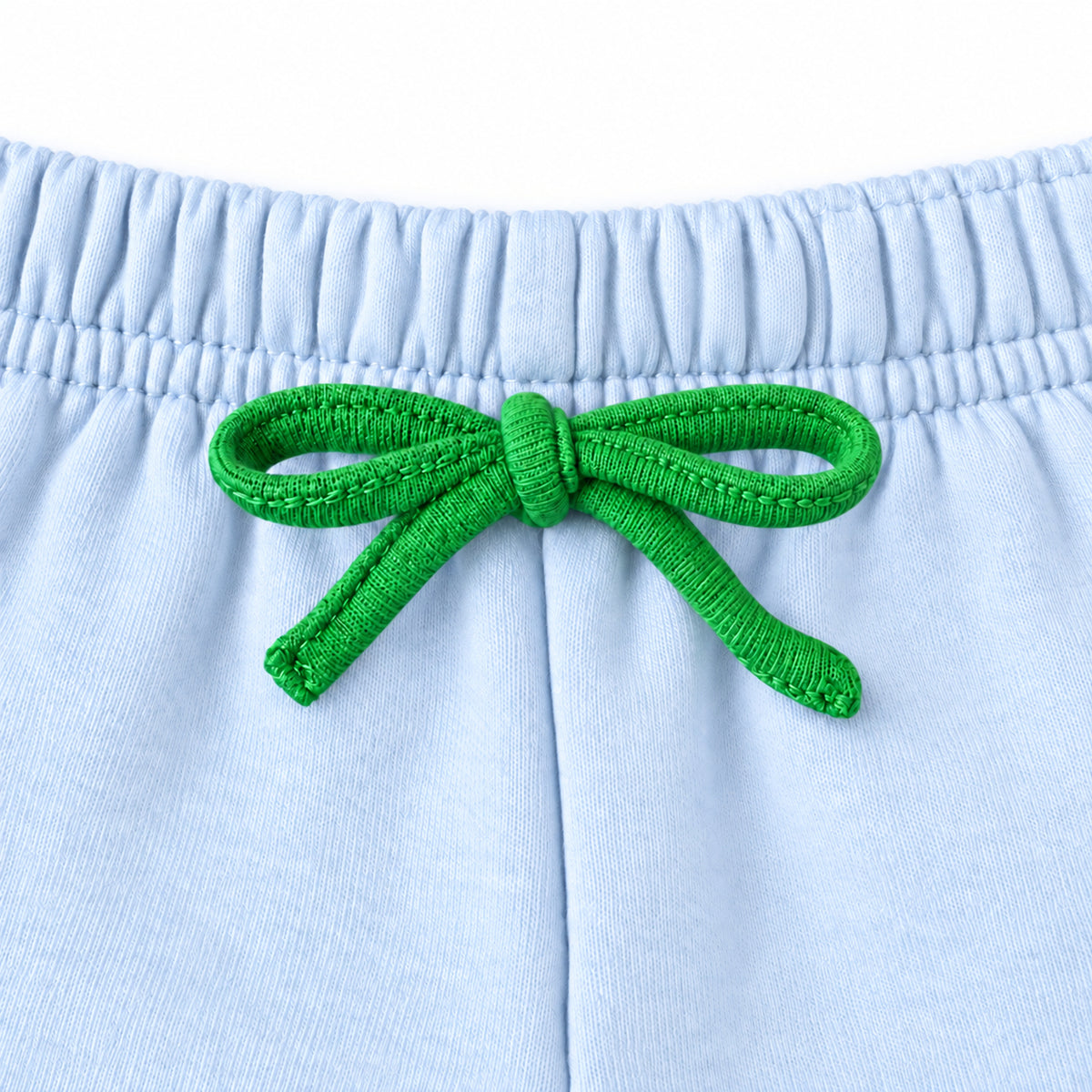 Close-up of the green drawstring tied in a bow at the elastic waistband
